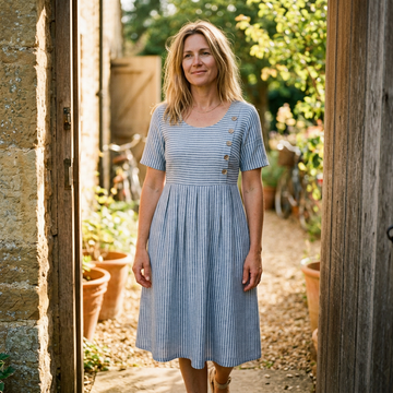 Striped midi dress in a sunlit doorway